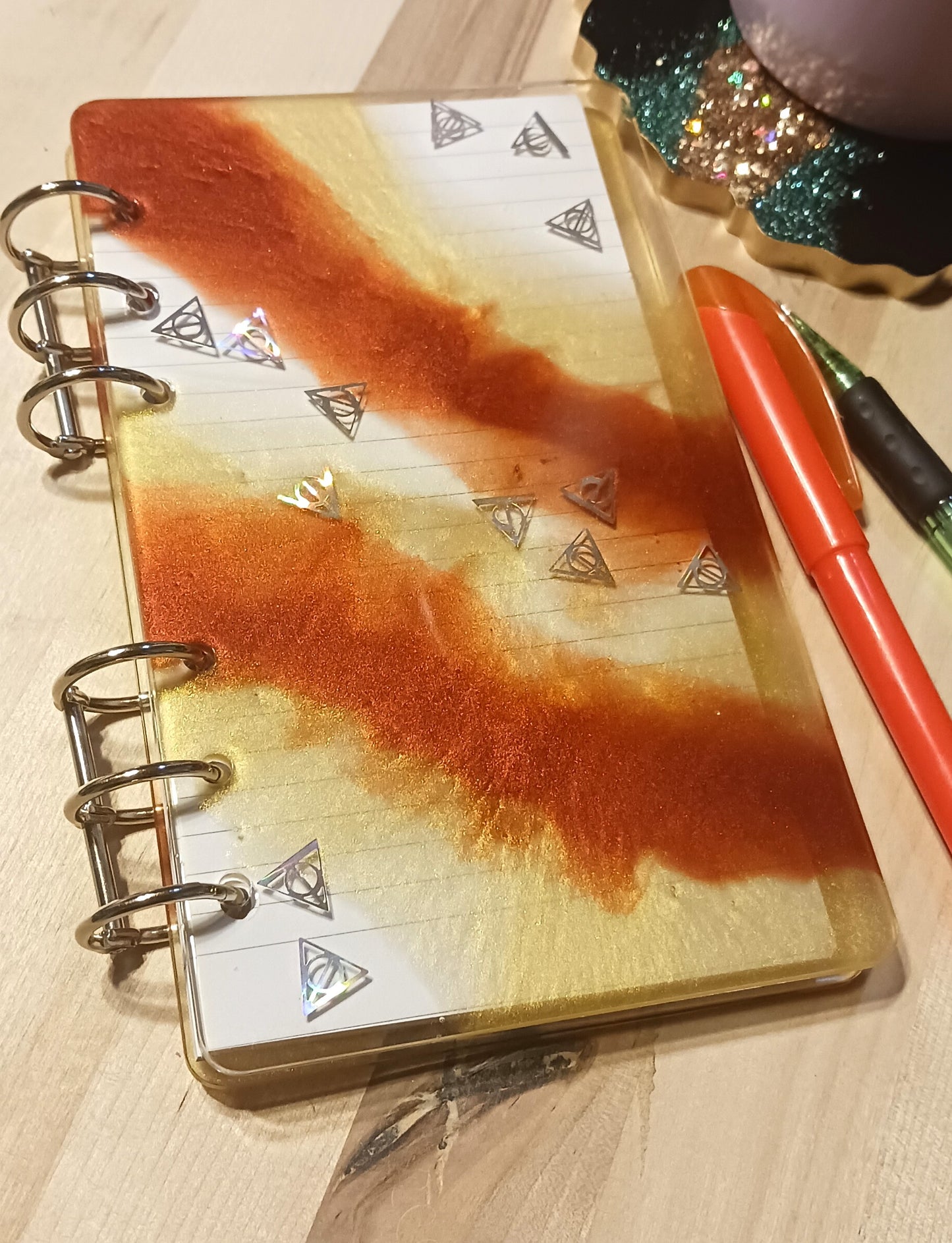 Red and gold resin notebook with iridescent Deathly Hallows confetti